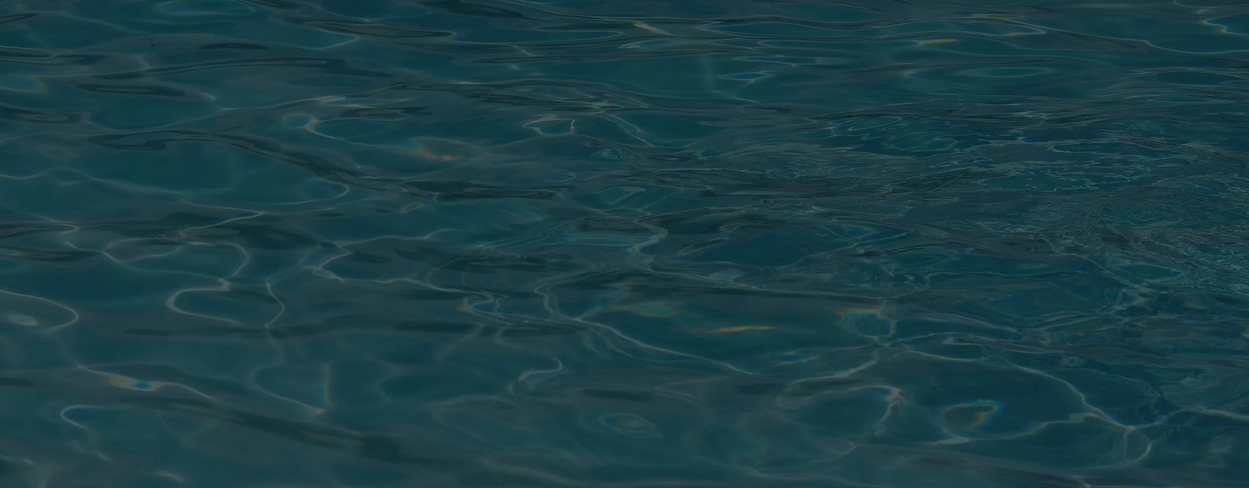Close-up of dark, rippling water with subtle reflections on the surface.