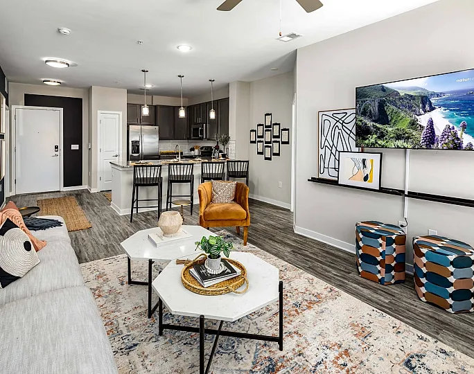 A cozy living room at Abberly Liberty Crossing Apartment Homes in Charlotte, featuring a comfortable couch and a stylish table. The space is well-lit and inviting, perfect for relaxation and socializing.