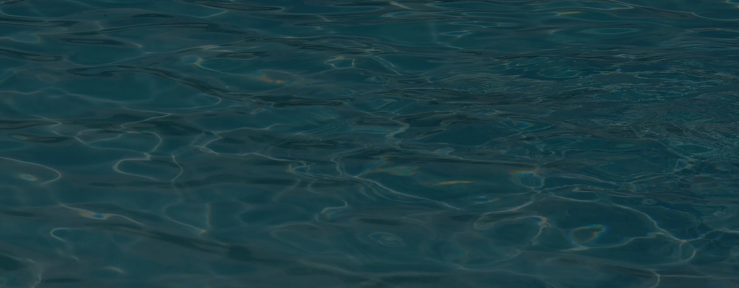Close-up of dark, rippling water with subtle reflections on the surface.