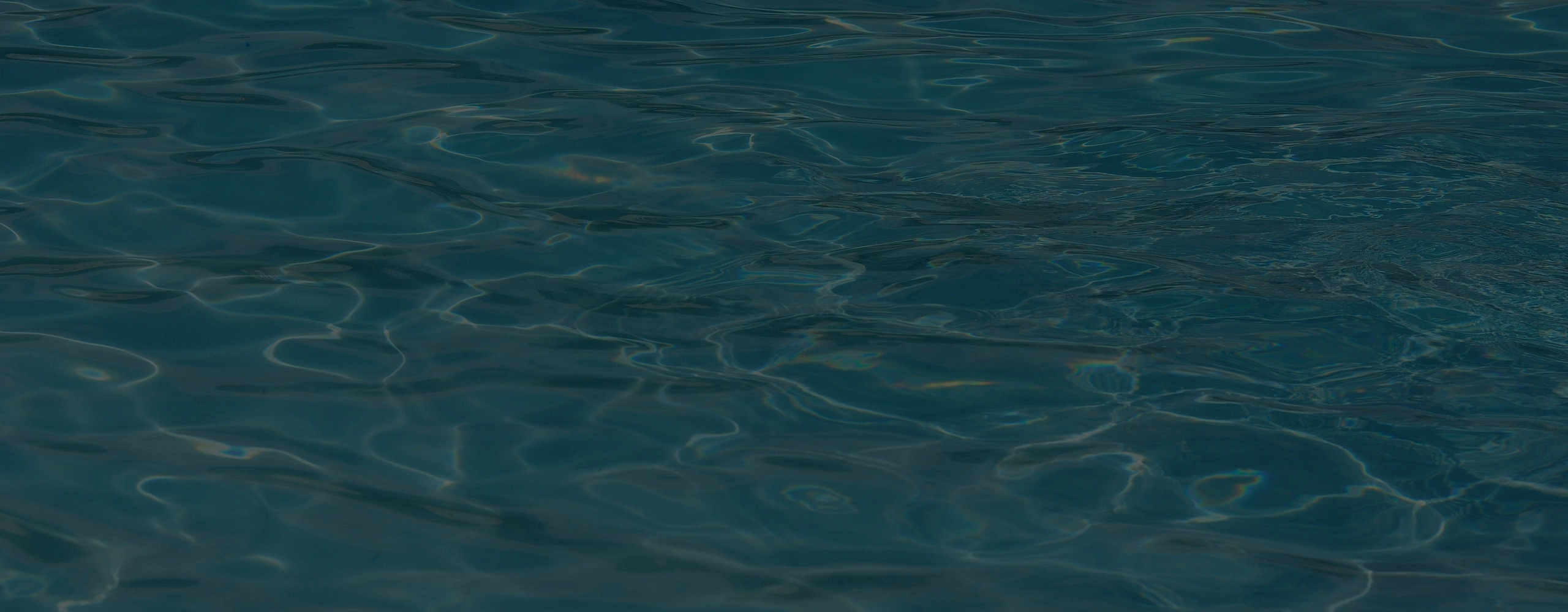 Close-up of dark, rippling water with subtle reflections on the surface.