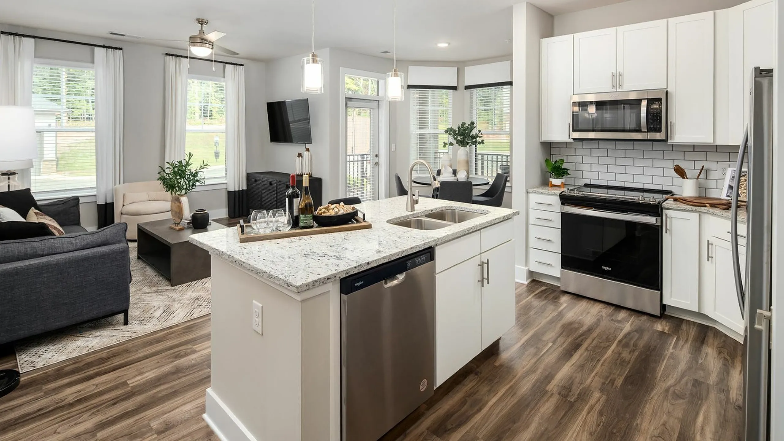 Kitchen with bar open to living room at Abberly Commons Apartments in Charlotte, NC