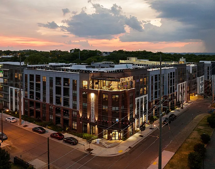 Dusk view of a modern, upscale apartment complex with sleek architecture and ambient lighting, labeled 'Foundry.'