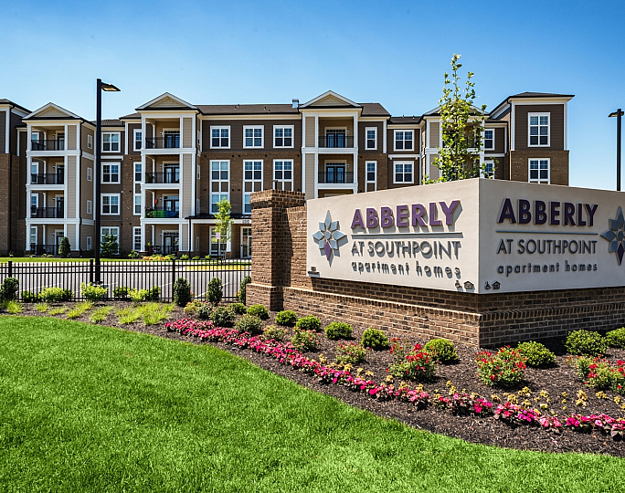 Elegant apartment complex with modern architecture and lush landscaping at Abberly at Southpoint.