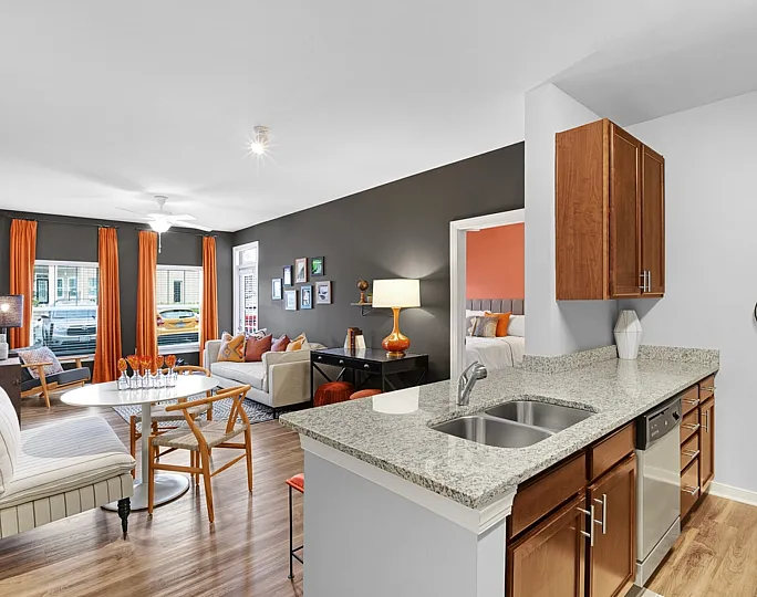 Chic open-plan living space with sleek kitchen, modern decor, and vibrant accents; perfect for stylish urban living.