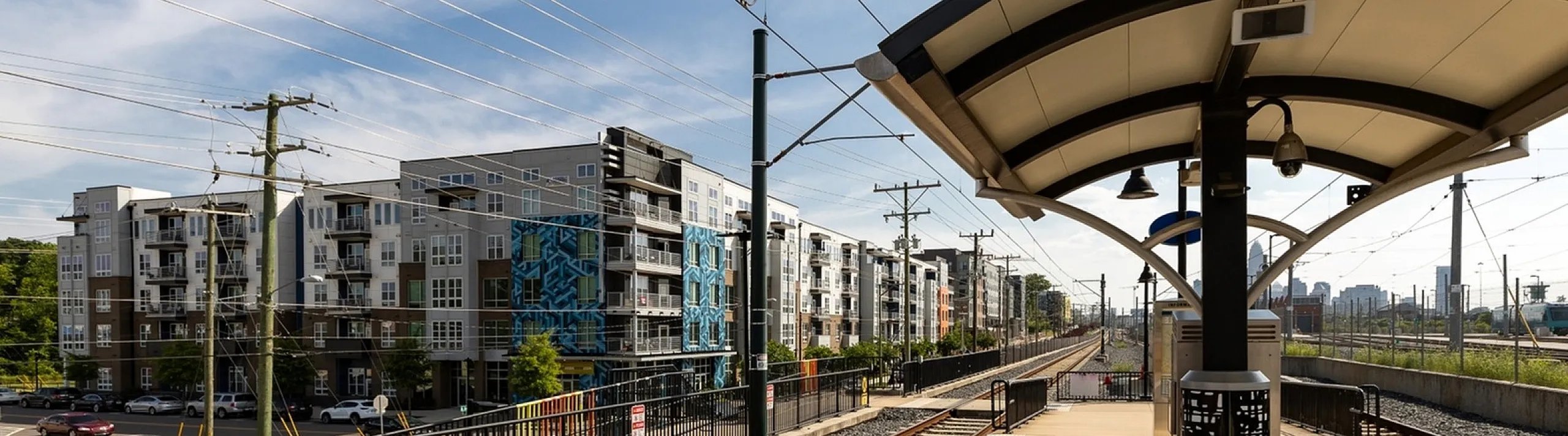 Modern urban living with convenient train station access and contemporary residential buildings in the background.