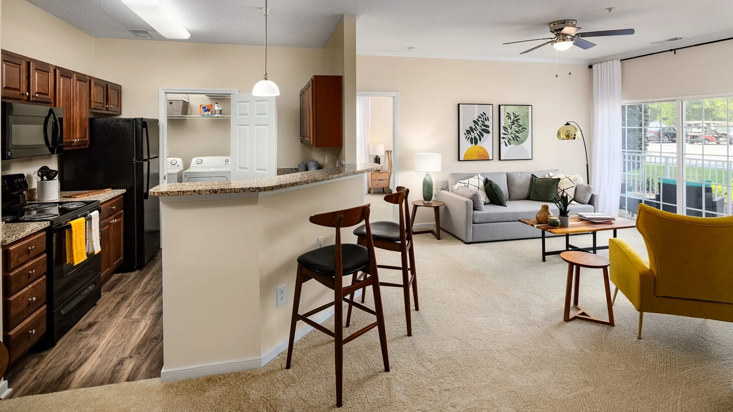 Contemporary apartment interior showcasing a cozy open-concept kitchen with a breakfast bar, stylish living area with modern decor, and large windows for natural light.