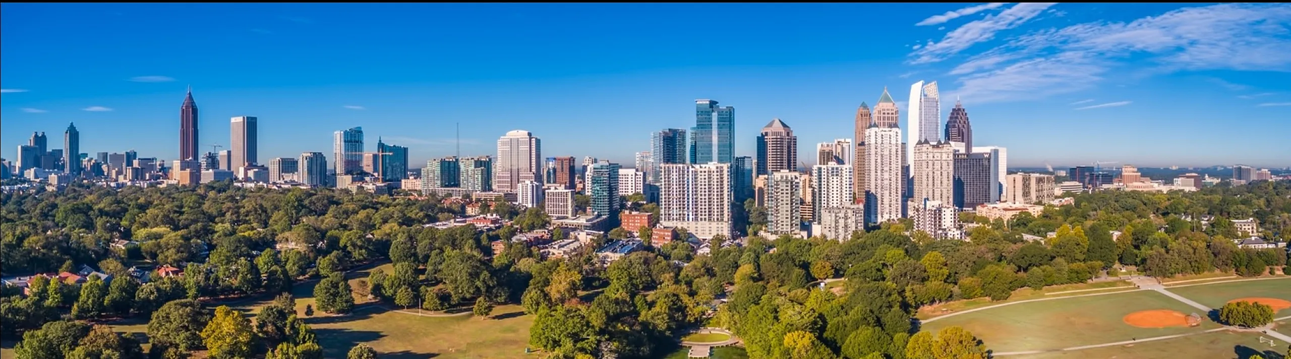 Breathtaking aerial view of a vibrant city skyline surrounded by lush greenery and a serene river, offering an ideal urban oasis.