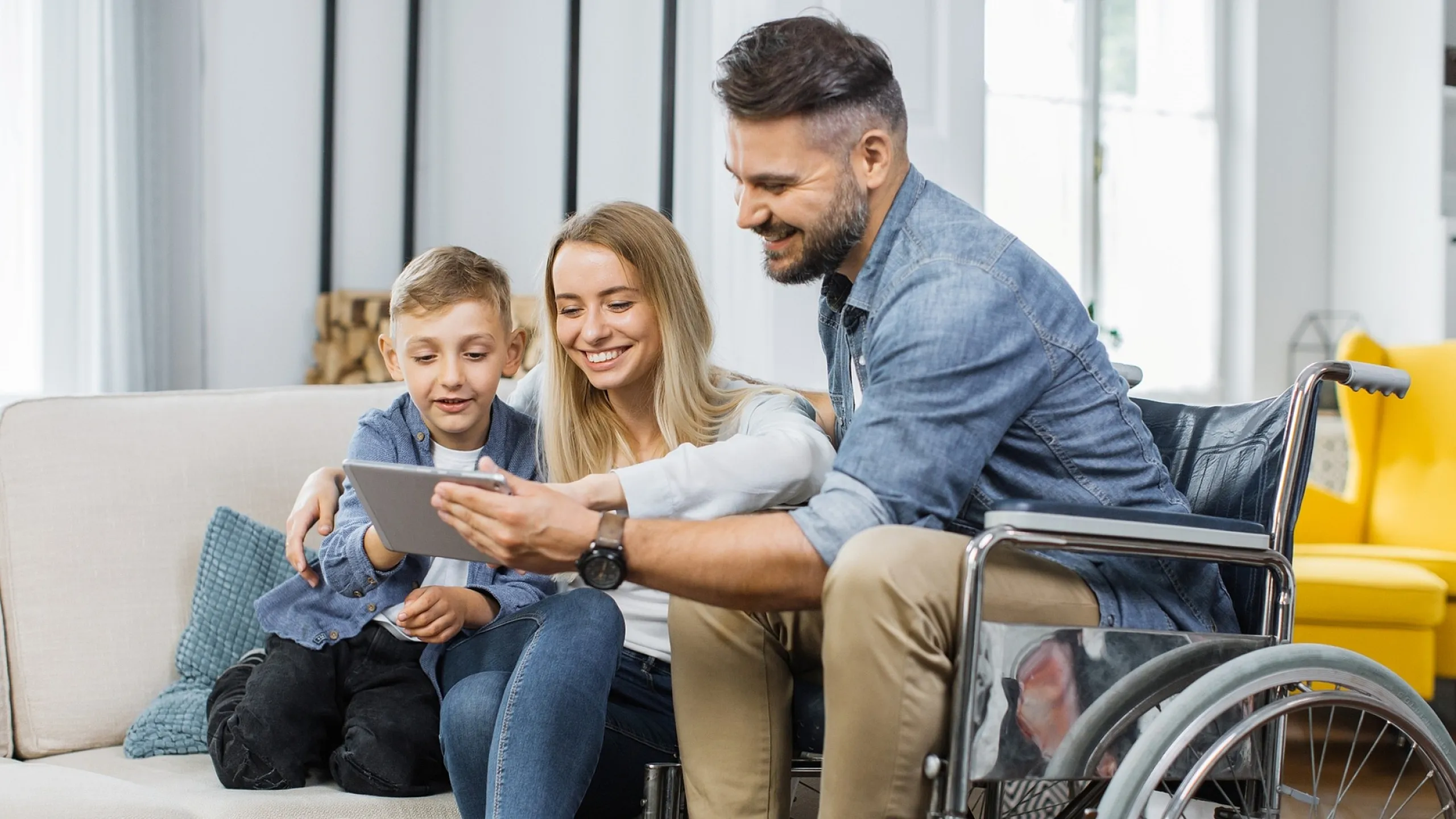 Happy family engaging with a tablet together in a cozy living room, emphasizing family-friendly and accessible living space.