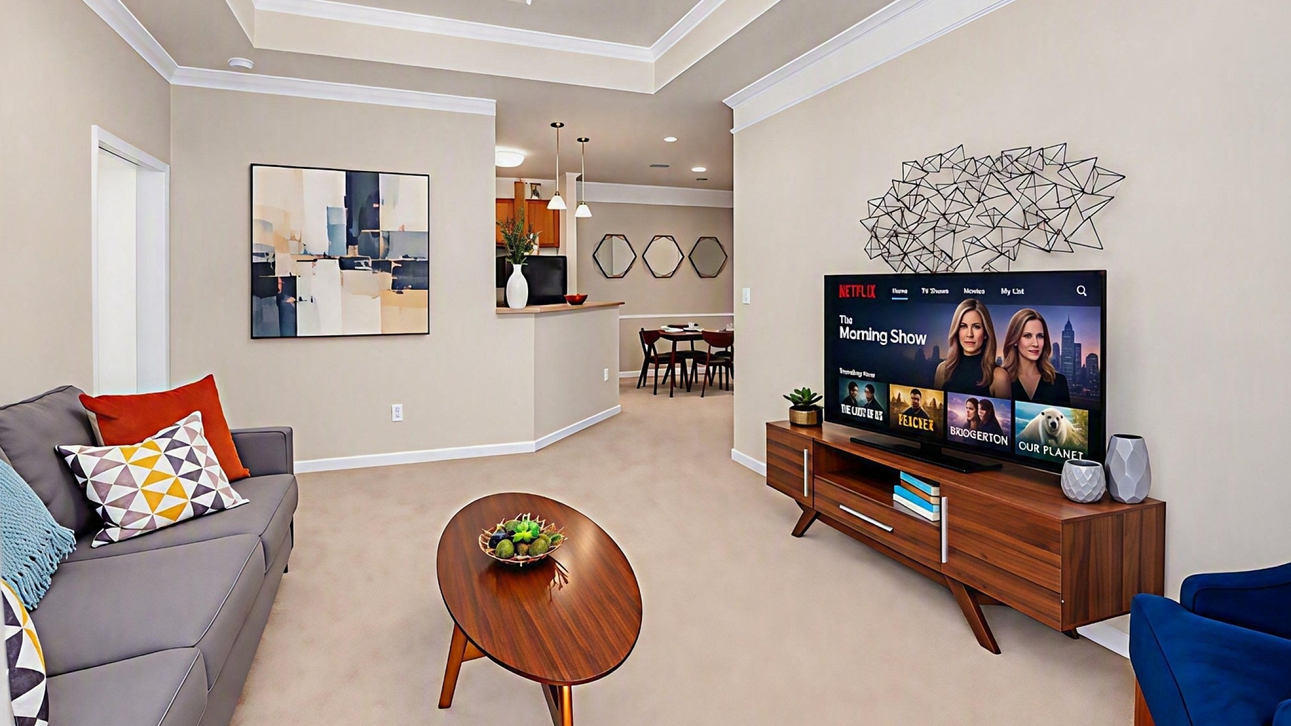 Modern living room with sleek decor, featuring a comfortable gray sofa, vibrant abstract art, and a stylish TV unit showcasing a large screen. Open layout leads to a dining area, creating an inviting and spacious atmosphere.