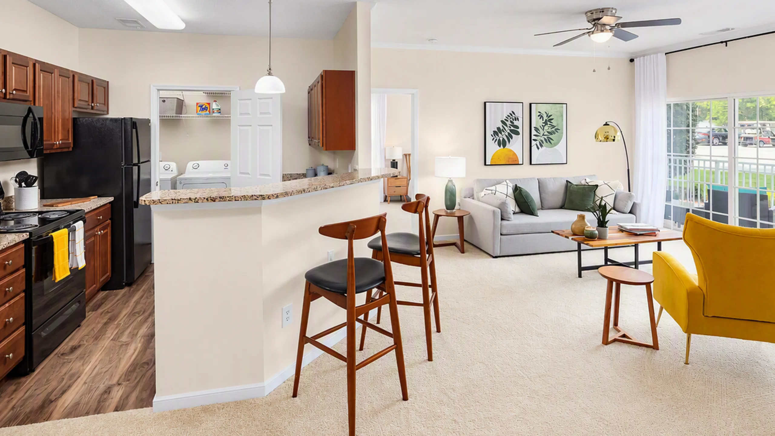 Bright and inviting living space with an open-concept layout featuring a modern kitchen, cozy seating area, and large windows filling the room with natural light.