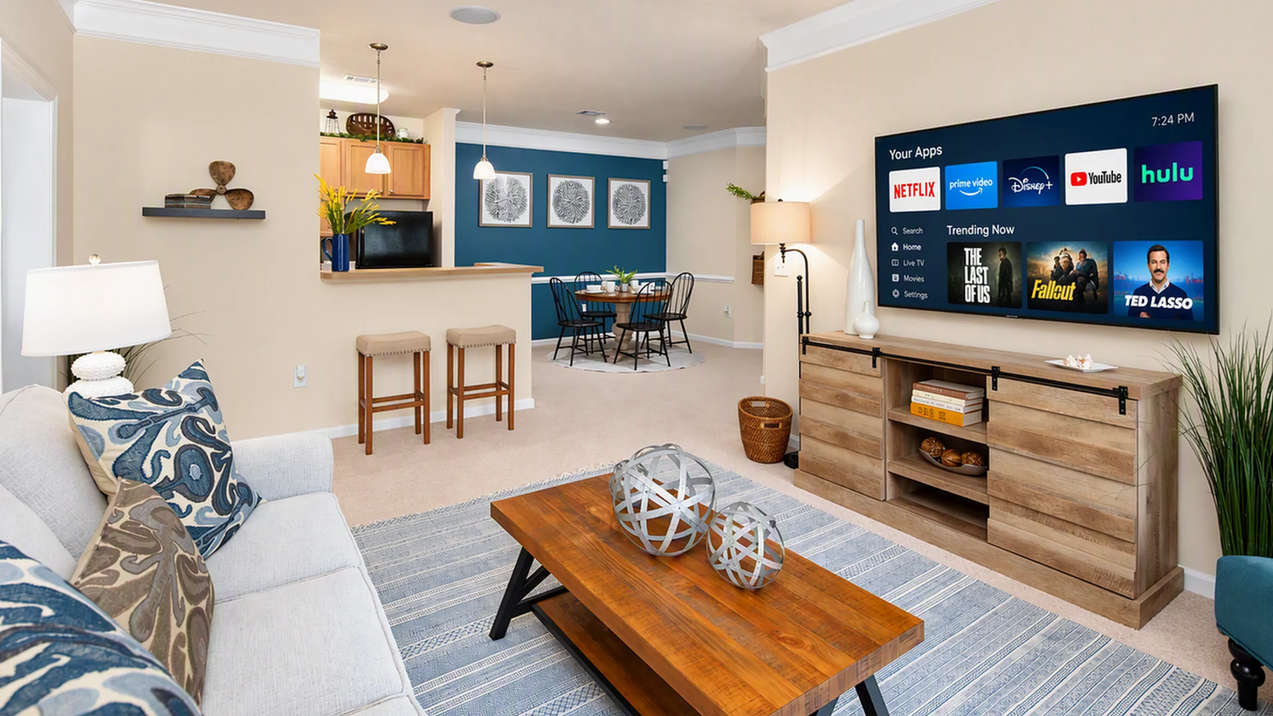 Inviting open-concept living area featuring a cozy sofa, stylish coffee table, and modern entertainment center. Elegant dining space and contemporary kitchen with bar seating create a perfect balance of comfort and style.