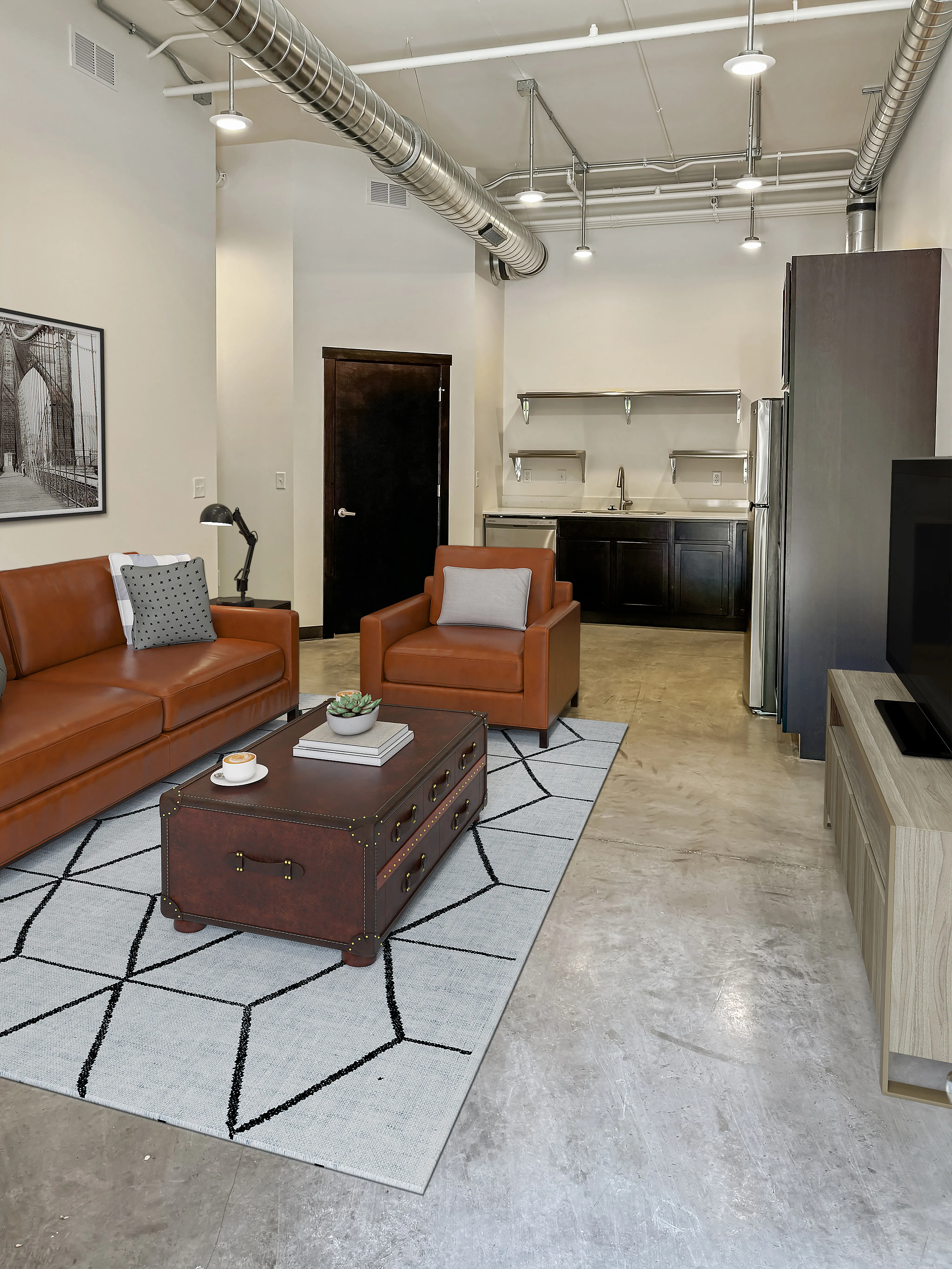 Chic industrial-style apartment with leather seating, modern kitchen, and stylish decor, perfect for urban living.