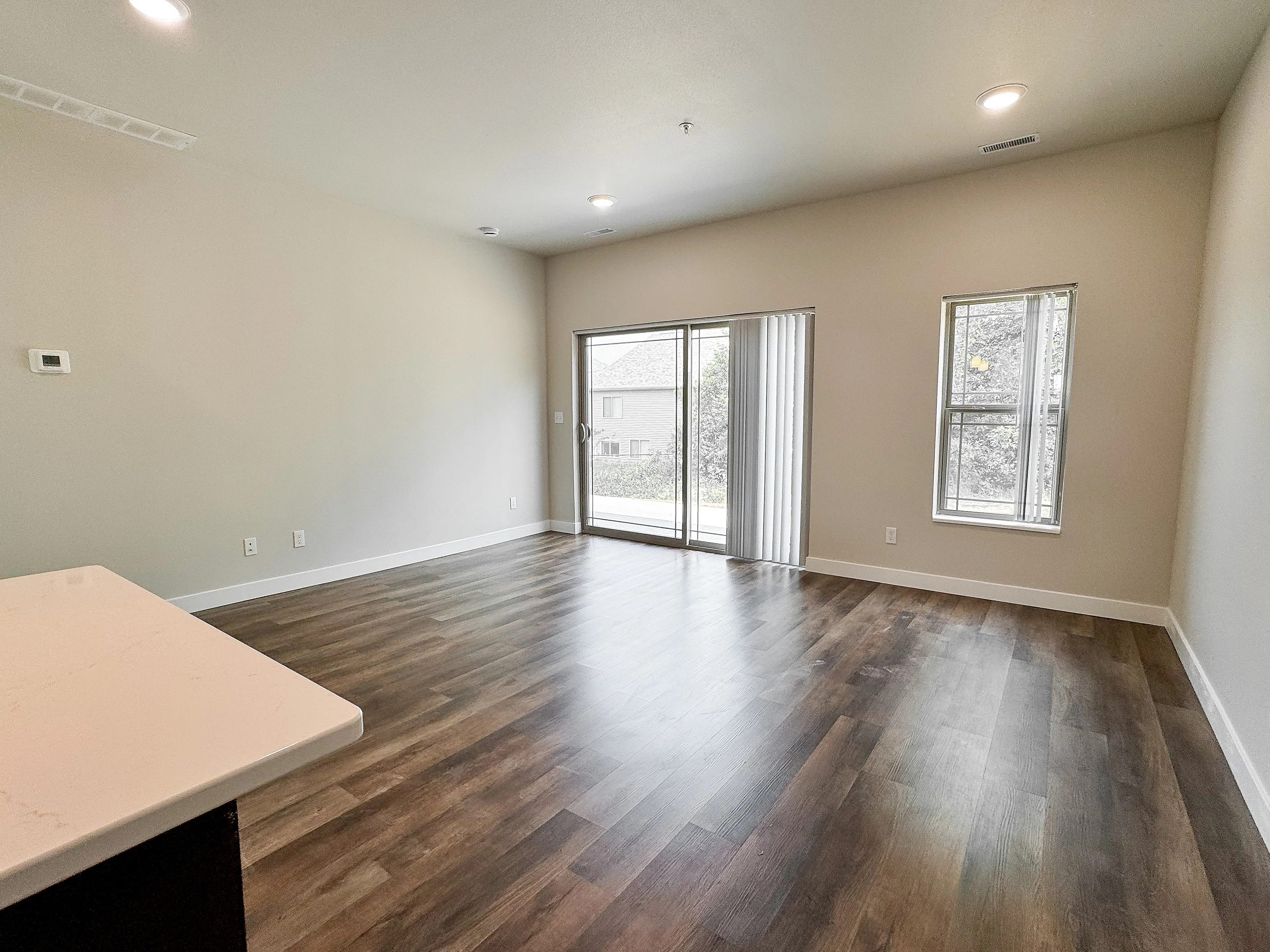 Bright and airy living room with sleek wood flooring and large windows offering natural light.