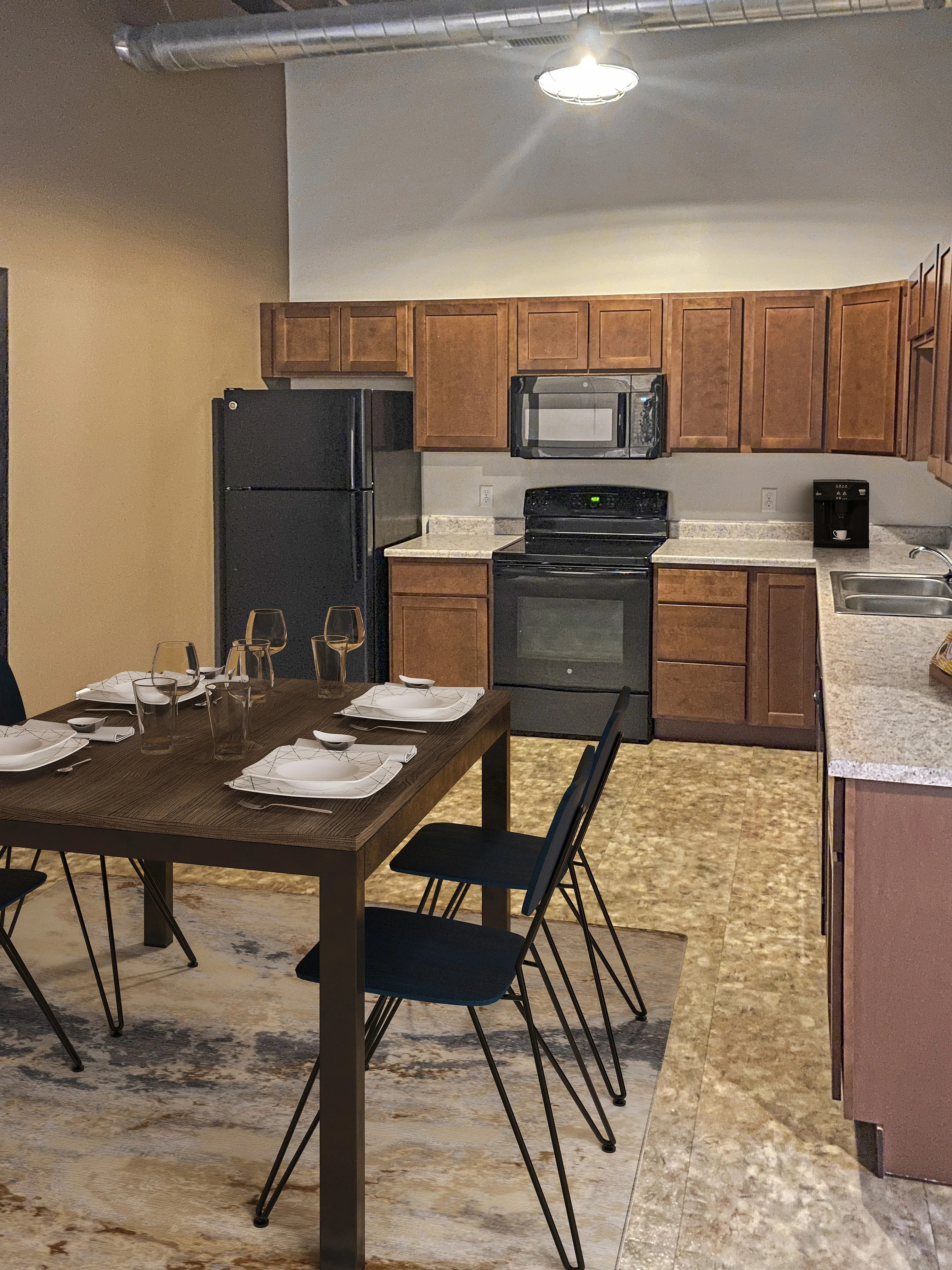 Modern kitchen with contemporary cabinetry, sleek black appliances, and a cozy dining area for four.