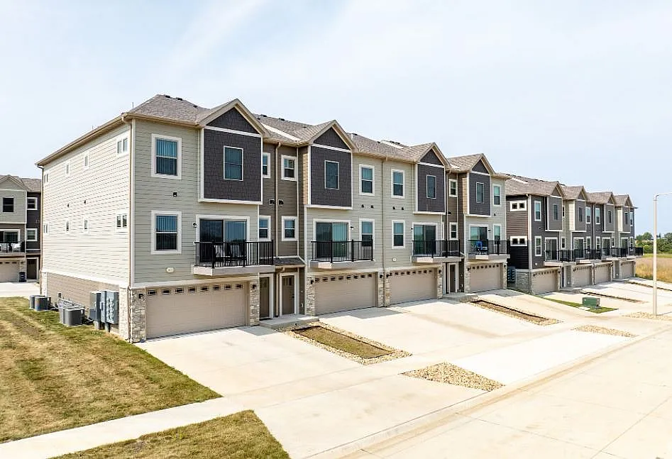 Modern townhouse complex showcasing elegant multi-story homes with spacious balconies and attached garages in a serene neighborhood setting.