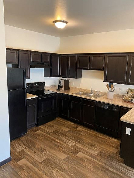 Contemporary kitchen with elegant dark wood cabinets, modern appliances, and sleek countertops, perfect for culinary enthusiasts.