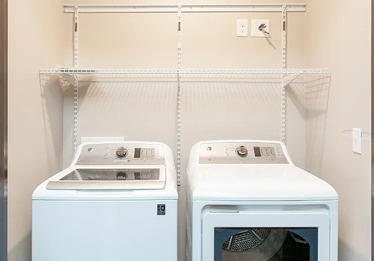 Modern laundry area with sleek washer and dryer, complemented by convenient shelving for organized storage.