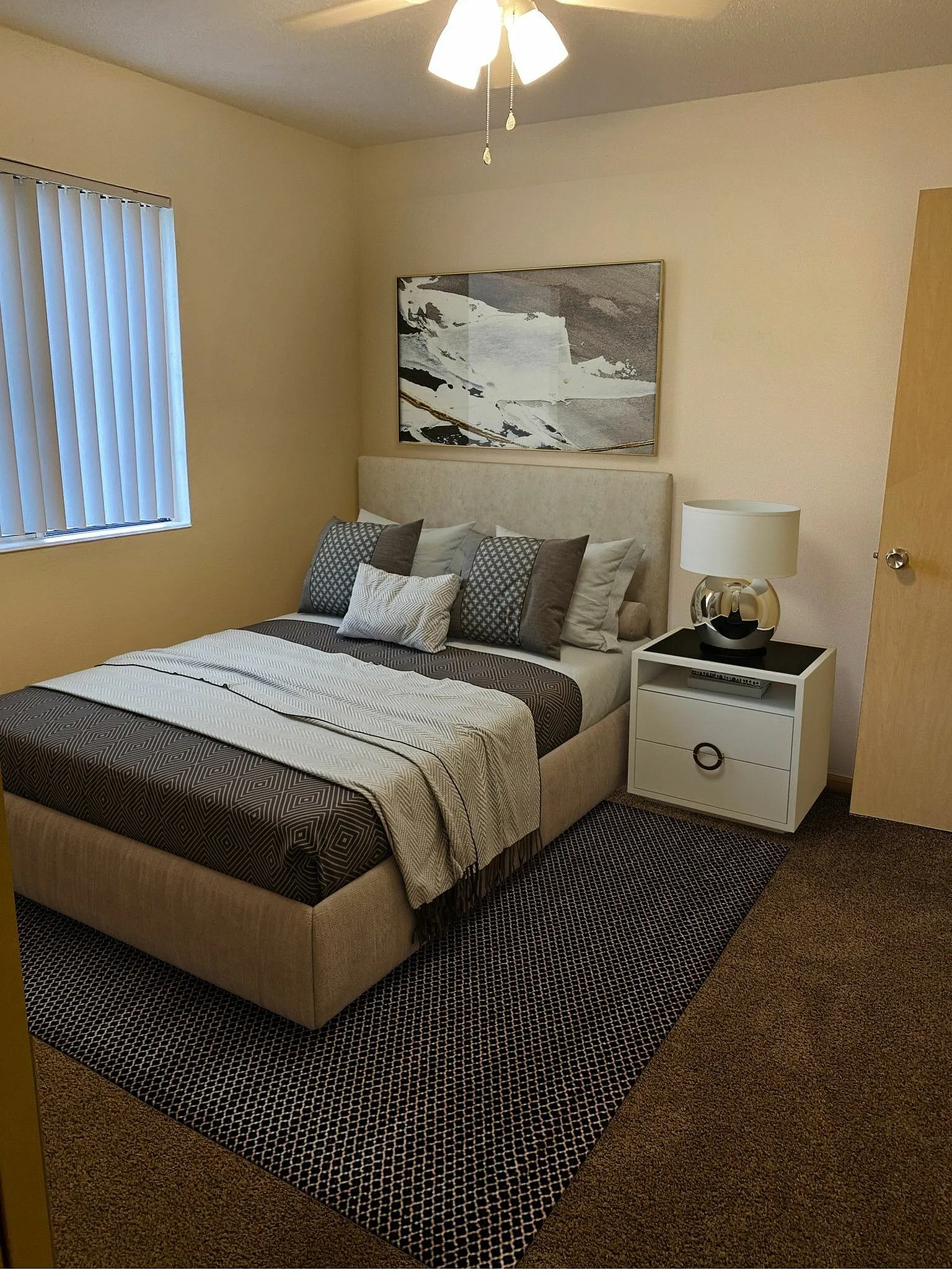 Inviting bedroom featuring a plush bed with stylish pillows, elegant bedside table, and soothing neutral tones, perfect for relaxation.