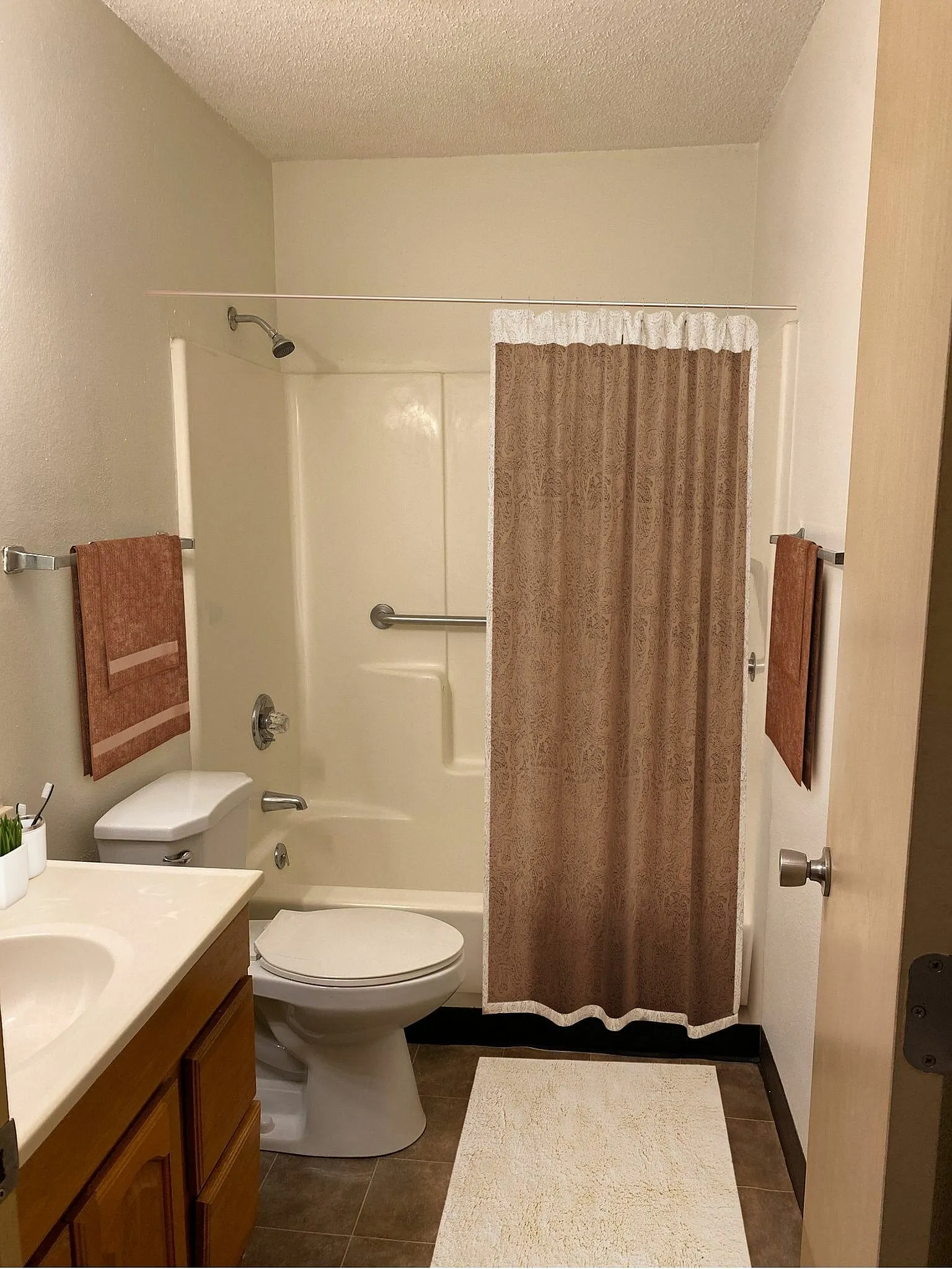 Cozy bathroom featuring a sleek bathtub with a patterned curtain, modern fixtures, and a stylish vanity.
