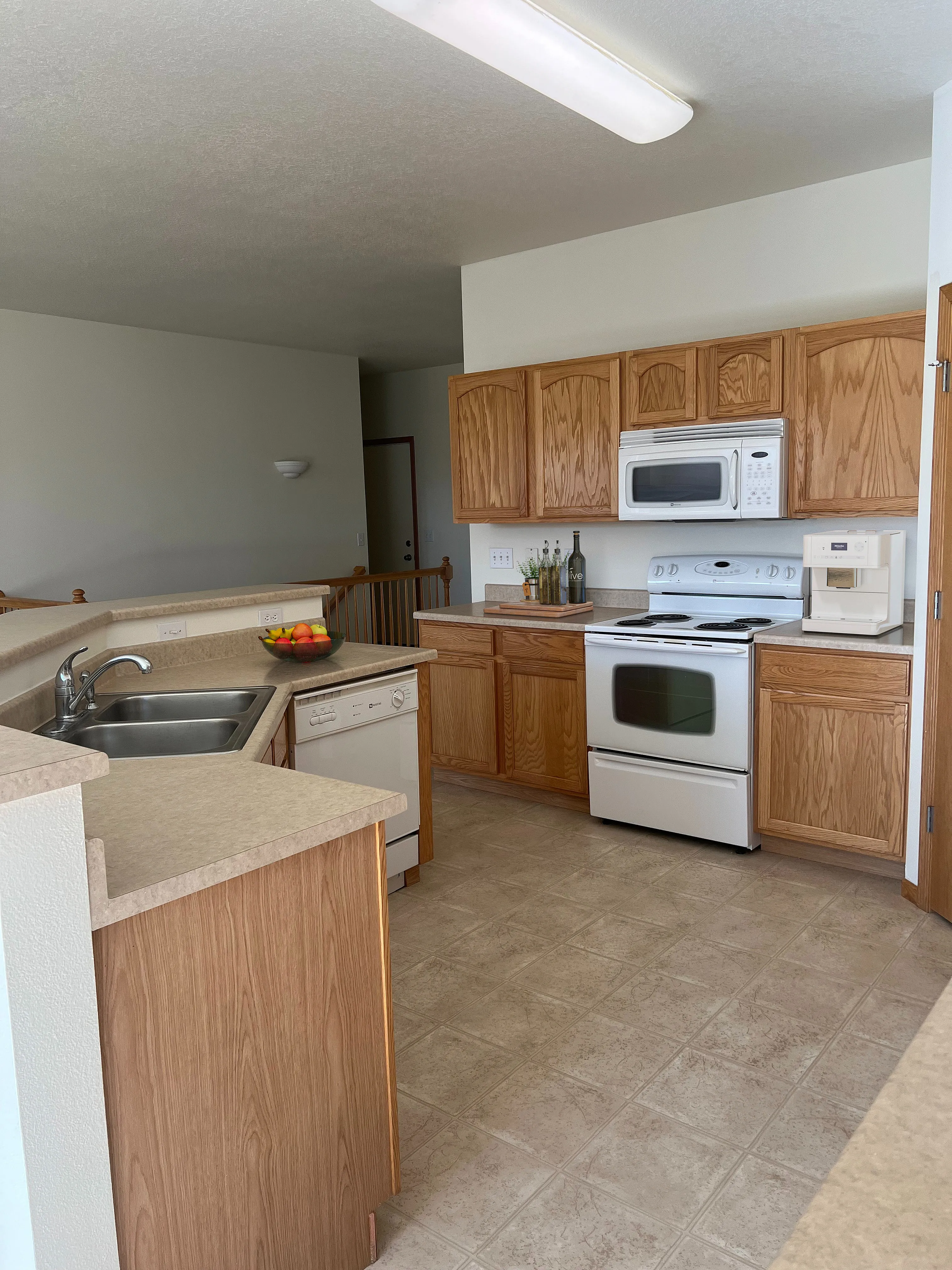 Inviting kitchen with modern appliances, ample wood cabinetry, and sleek countertops, perfect for culinary enthusiasts.