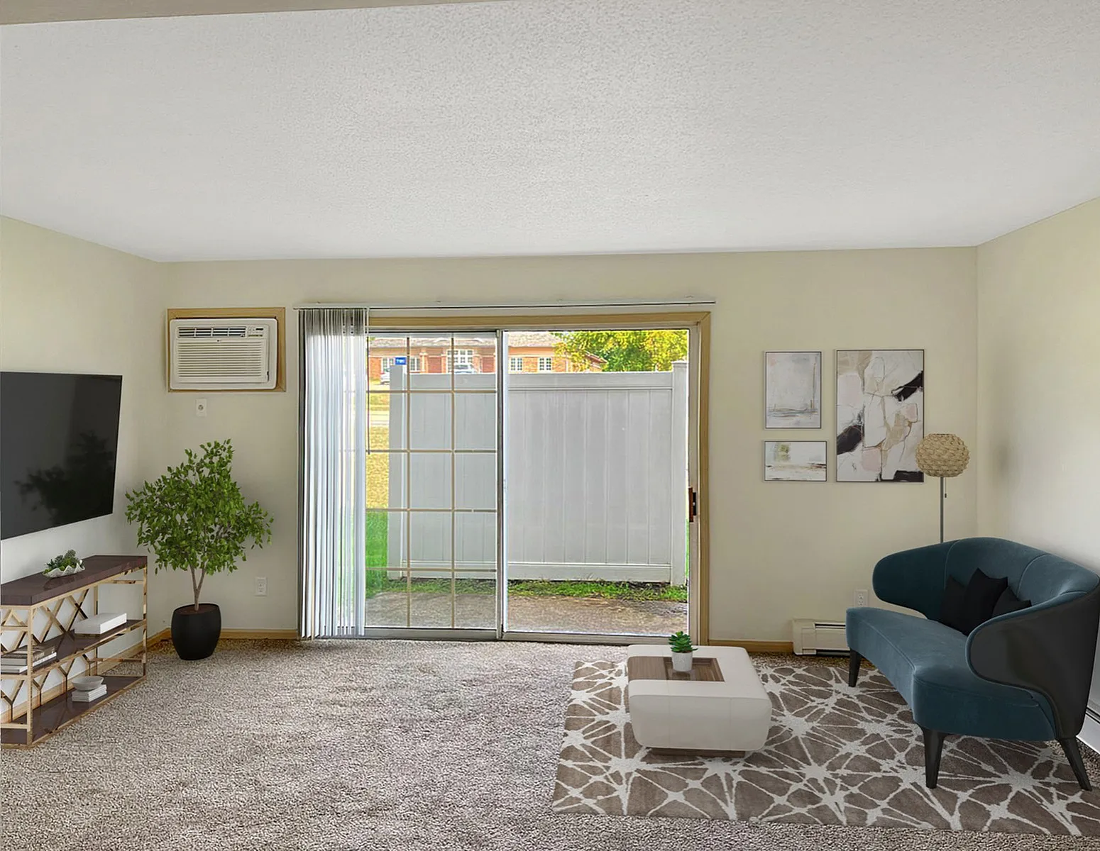 Bright and inviting living room with modern decor, featuring a plush blue sofa, elegant artwork, and large sliding glass doors leading to a serene outdoor view.