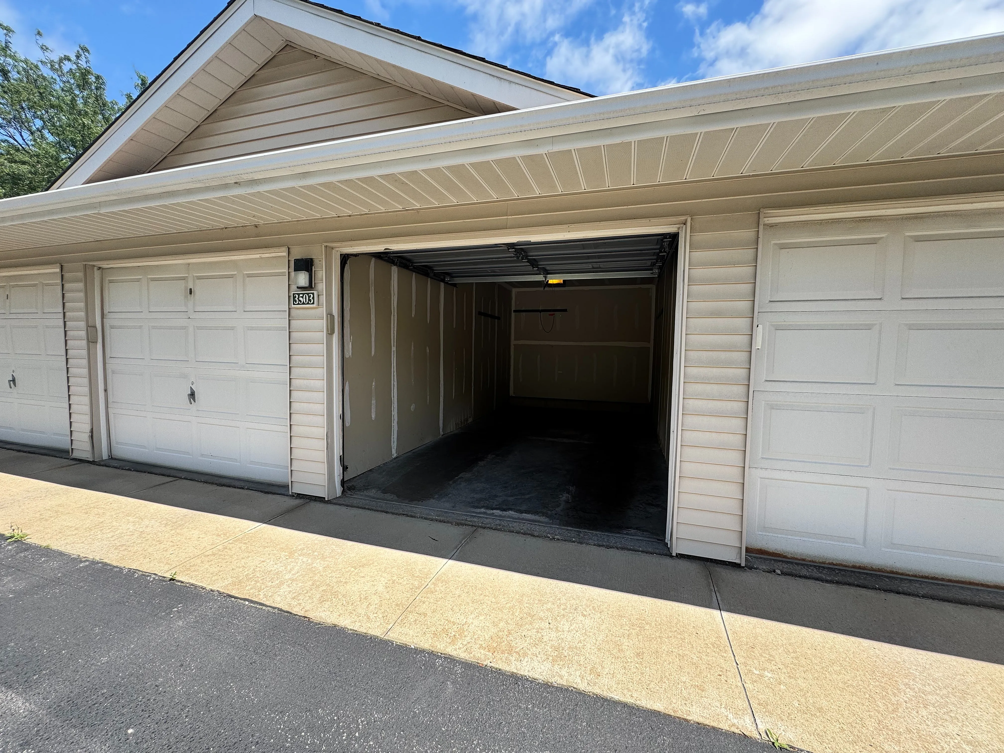 Inviting and spacious garage with wide-open doors, perfect for vehicle storage or a creative workspace.