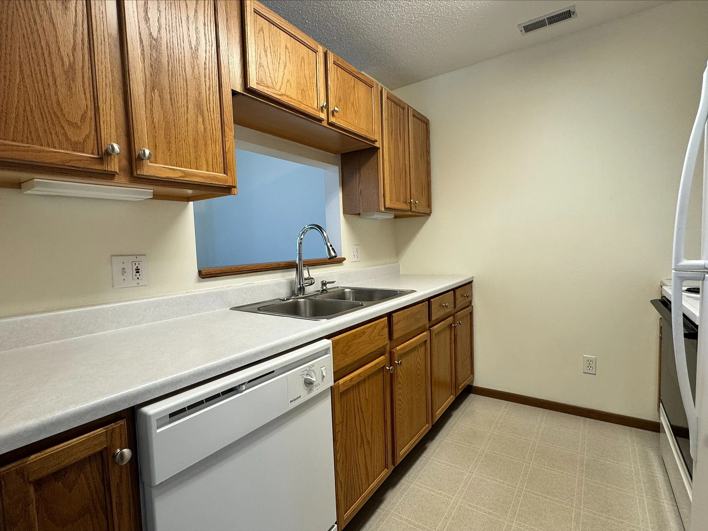 Inviting kitchen with warm wooden cabinets, sleek countertops, and modern appliances, perfect for culinary creativity.