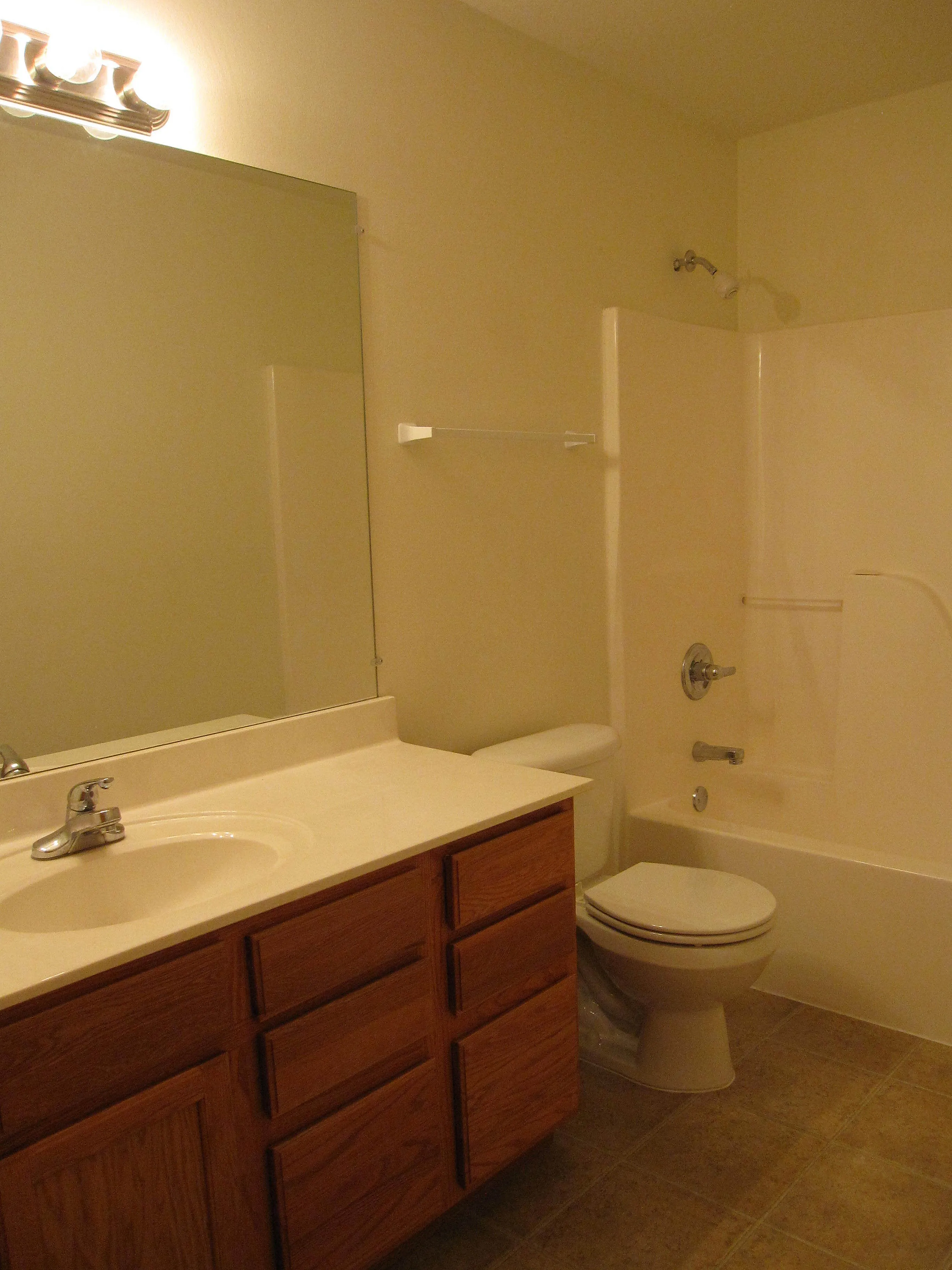 Inviting bathroom with modern fixtures, elegant vanity, and a spacious shower-tub combo.