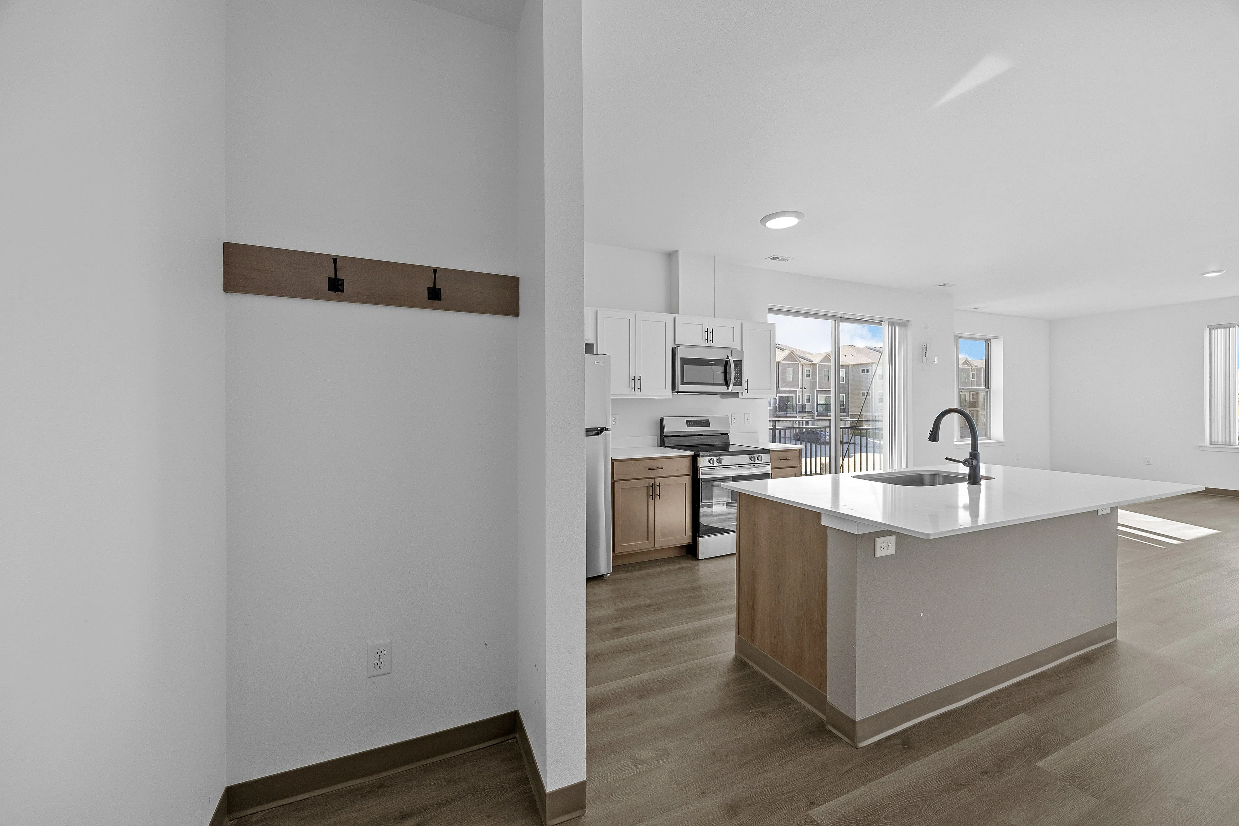 Bright and modern kitchen with sleek island, stainless steel appliances, and large windows offering natural light.