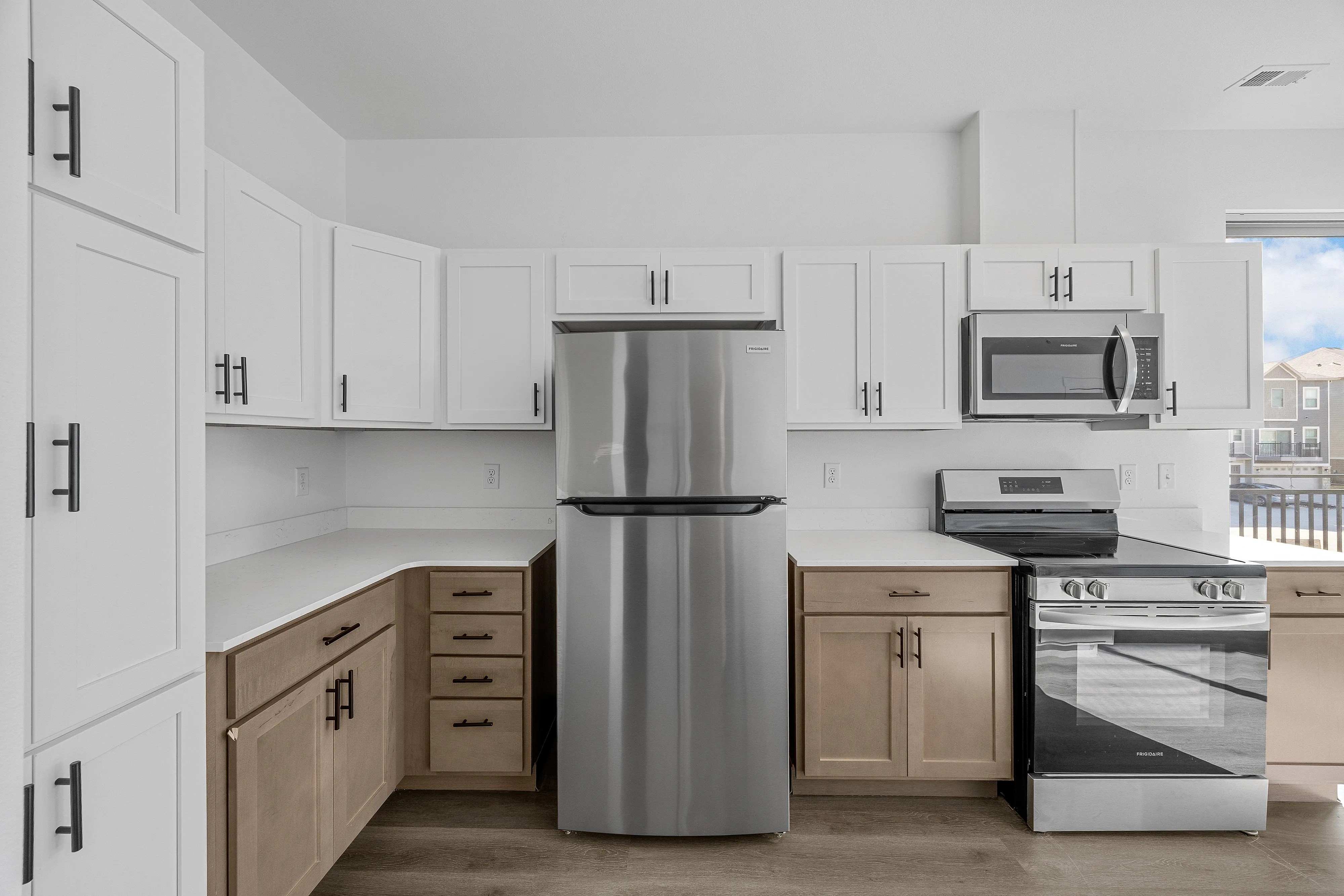 Modern kitchen with sleek stainless steel appliances, elegant white cabinetry, and a spacious countertop offering a bright and welcoming atmosphere.