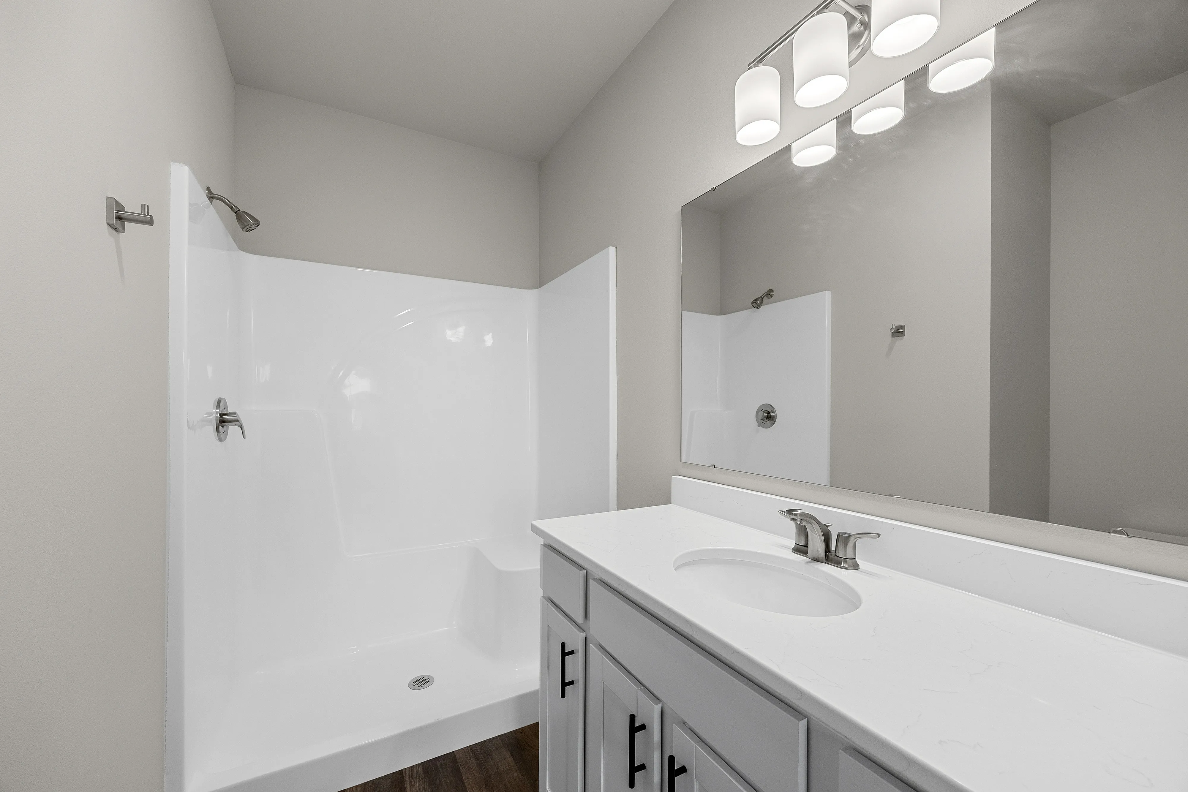 Elegant bathroom with modern white fixtures, spacious countertop, and sleek lighting, offering a bright and inviting atmosphere.