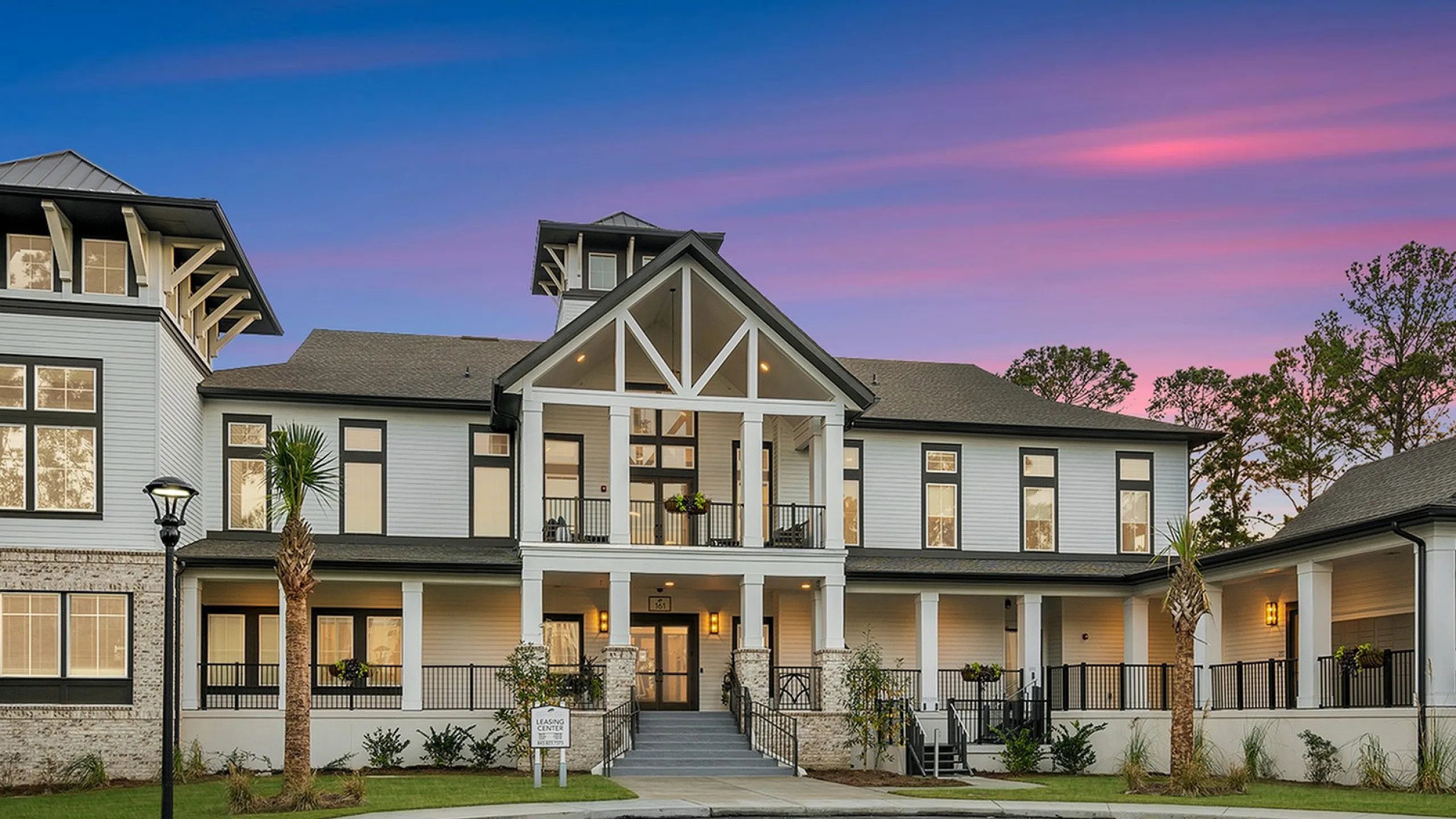 Elegant modern apartment building with stunning evening sky backdrop, highlighting grand architecture and inviting entrance.