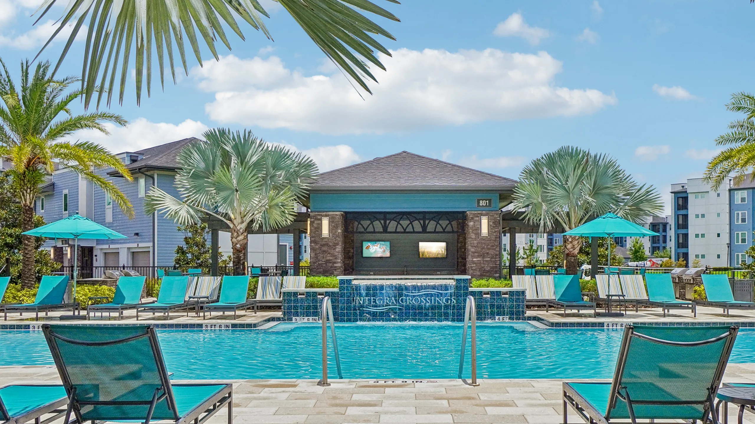 Vibrant resort-style pool area with luxurious loungers, tropical palm trees, and modern apartments in the background.