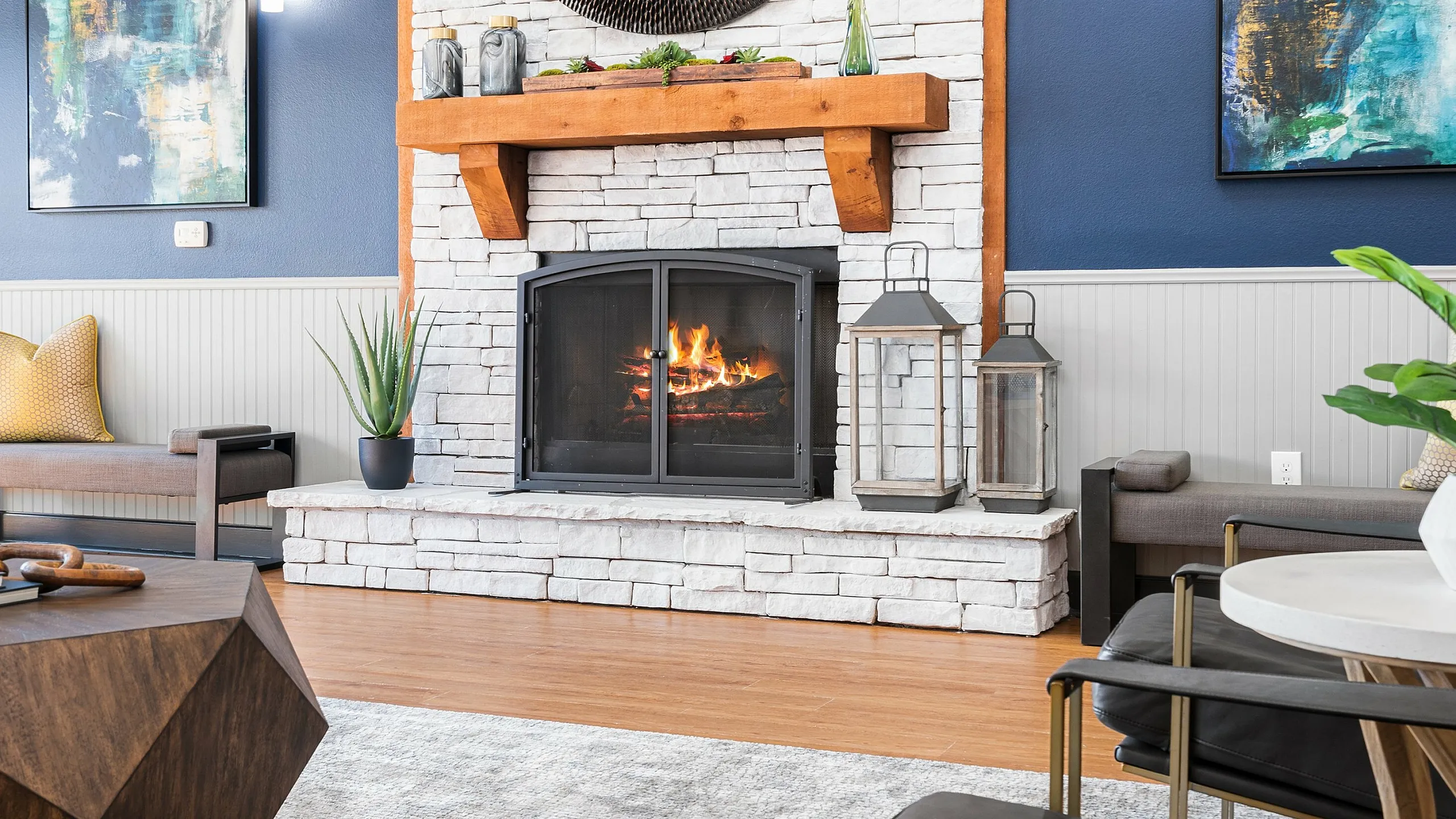 Chic living room boasting a cozy stone fireplace, abstract artwork, and modern furnishings creating an inviting atmosphere.