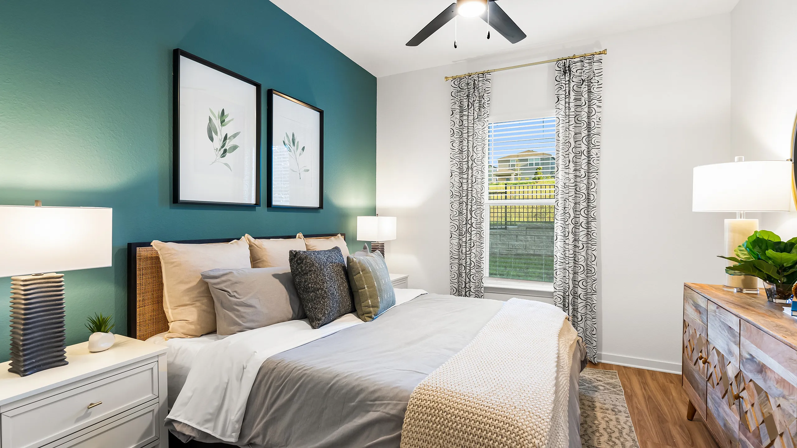 Chic bedroom featuring a plush bed with modern decor, elegant lighting, and a serene teal accent wall.