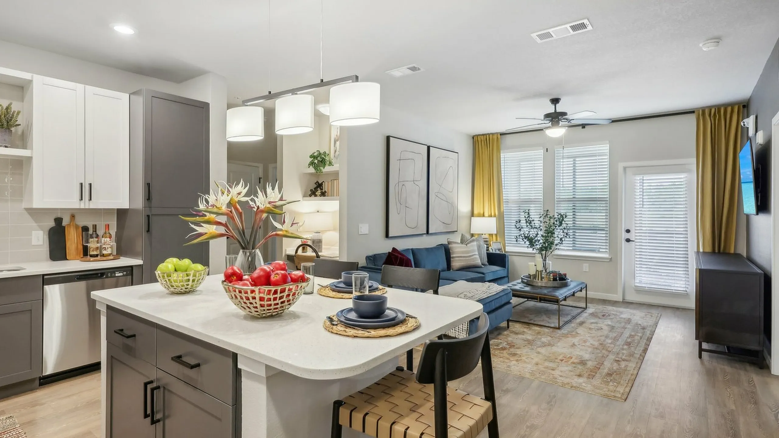 Modern open-concept living space featuring a sleek kitchen with a central island, cozy dining area, and stylish living room with elegant decor.