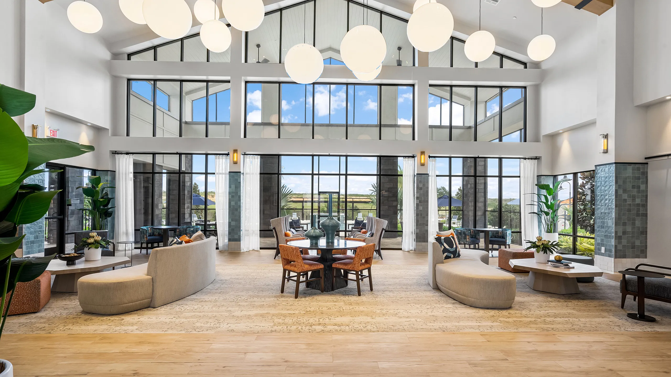 Elegant lounge area with large windows, contemporary furniture, and soft lighting, offering a spacious and welcoming ambiance.