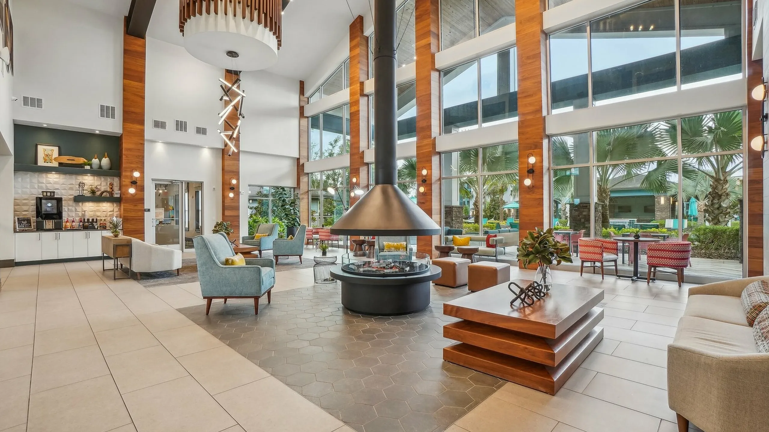Luxurious open-concept lounge area with modern decor, ample natural light, and expansive windows offering scenic outdoor views.