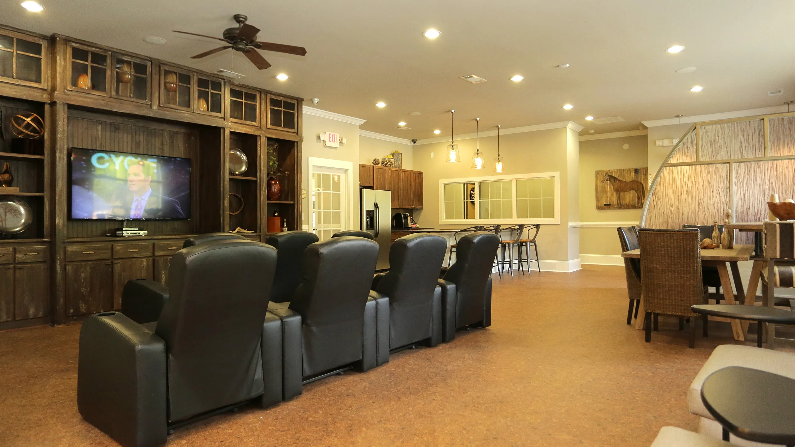 Luxurious community room featuring plush leather seating, modern kitchenette, and elegant dining area for social gatherings.
