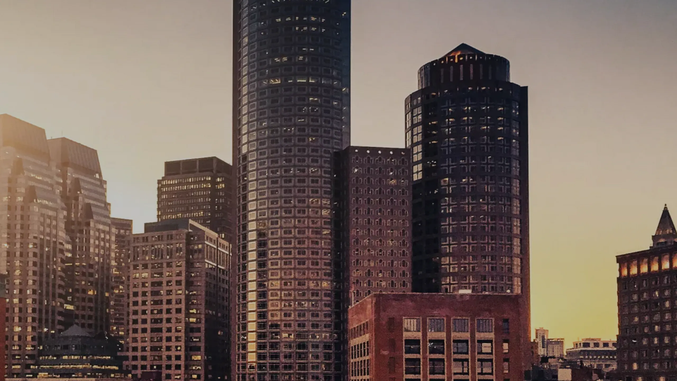Majestic city skyline at sunset featuring modern high-rise buildings with striking architecture.