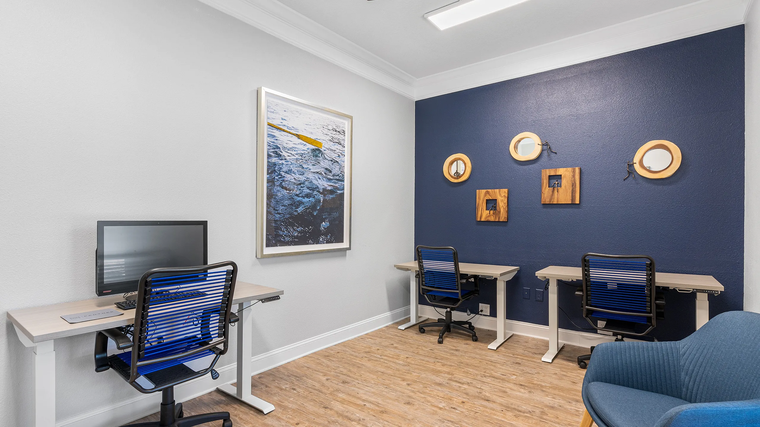 Modern home office with chic blue accent wall, stylish wood desks, and ergonomic chairs enhancing productivity.