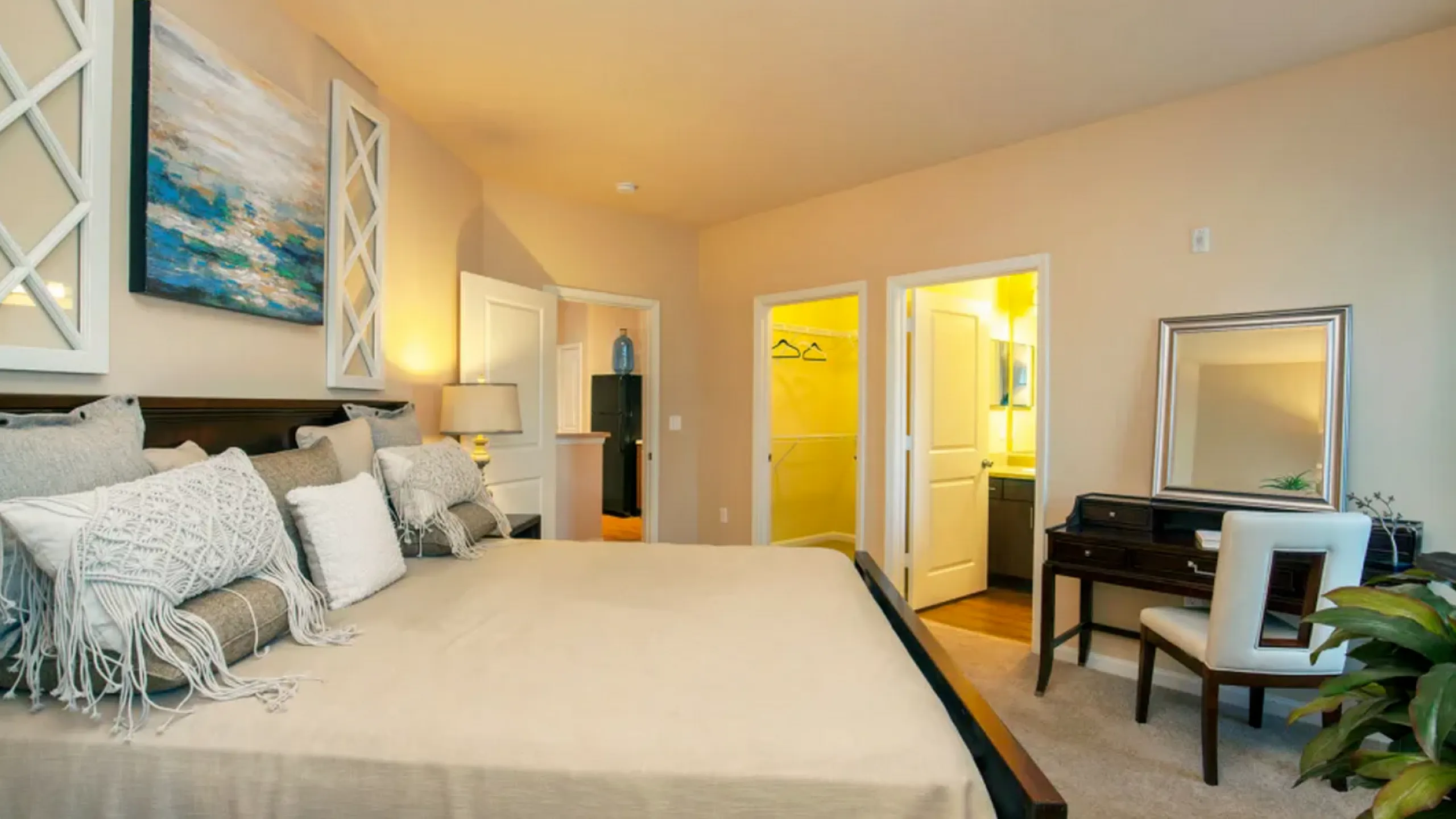 Elegant master bedroom with plush bedding, chic decor, walk-in closet, and en-suite bathroom.