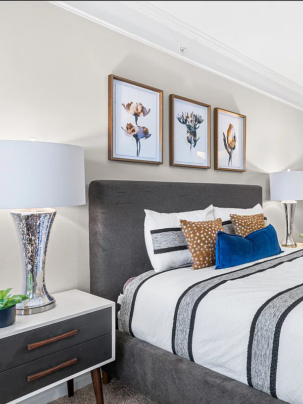Elegant bedroom with modern decor, featuring a plush bed, stylish artwork, and a spacious walk-in closet. Luxurious en-suite bathroom adds comfort and convenience.