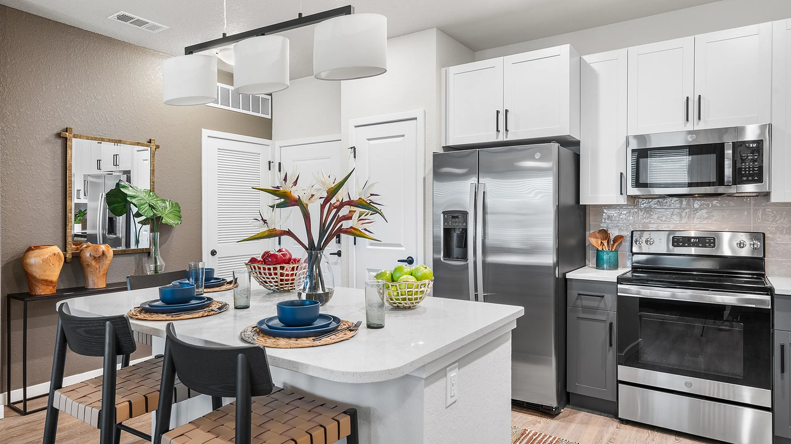 Modern kitchen with stylish white cabinets, stainless steel appliances, and a chic island with bar seating, perfect for entertaining.