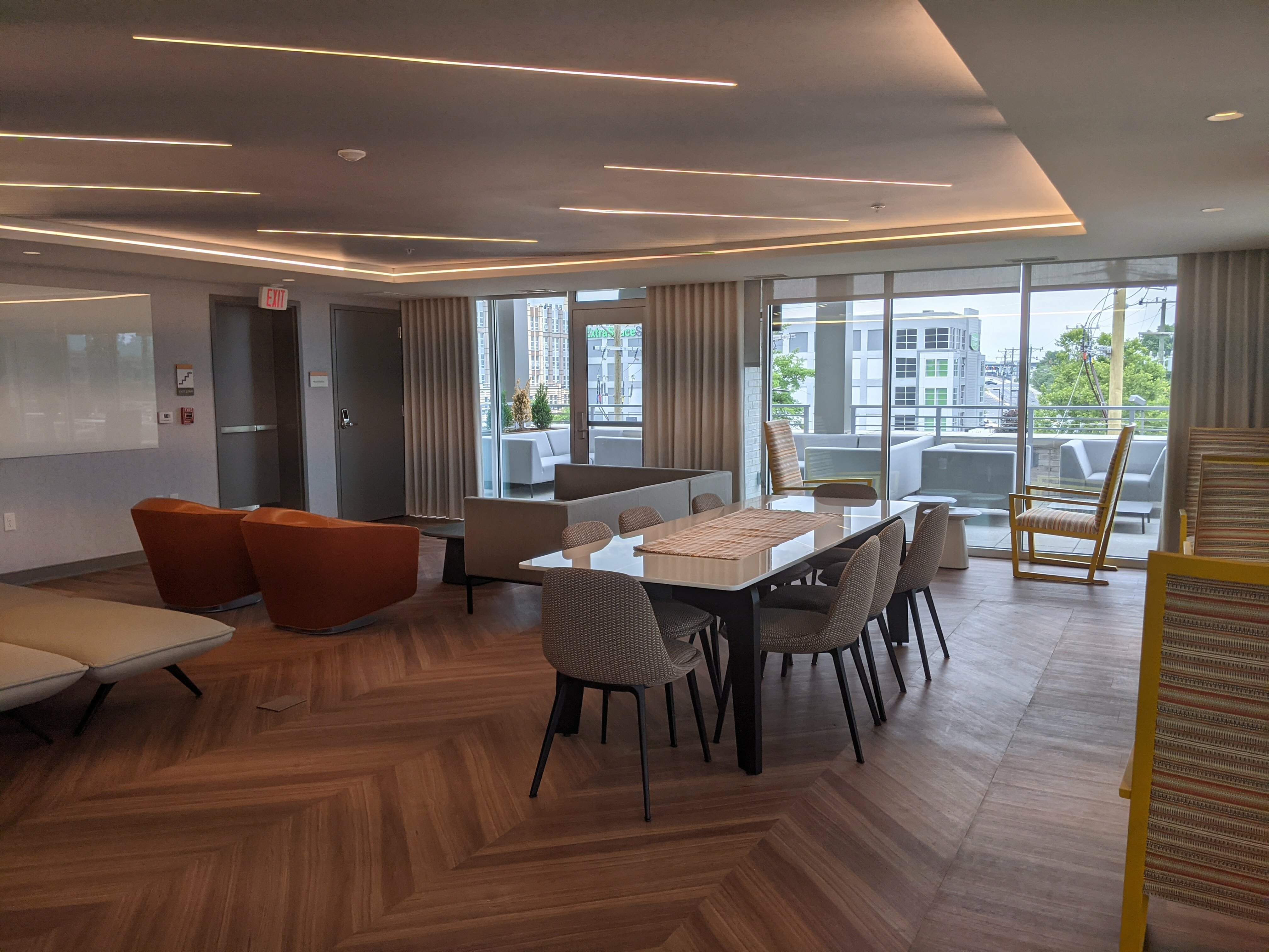 Elegant apartment common area with modern seating, vibrant natural light, and a spacious balcony view.