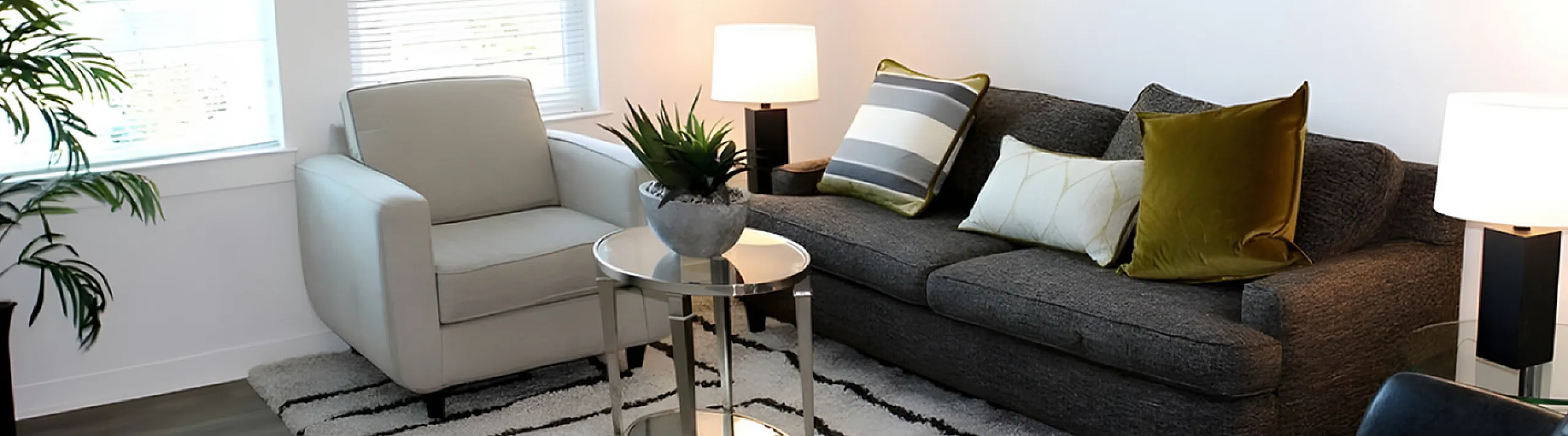 Modern living room with stylish seating, plush cushions, and warm lighting, creating a cozy, inviting ambiance.