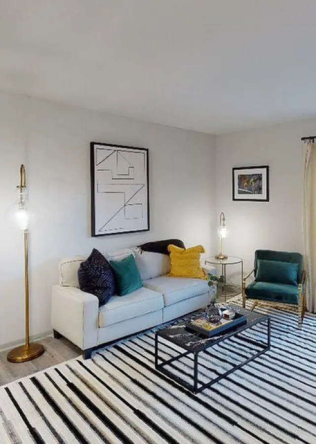 Bright and inviting living room featuring stylish decor, a comfortable sofa, modern armchair, and glass doors opening to a patio.