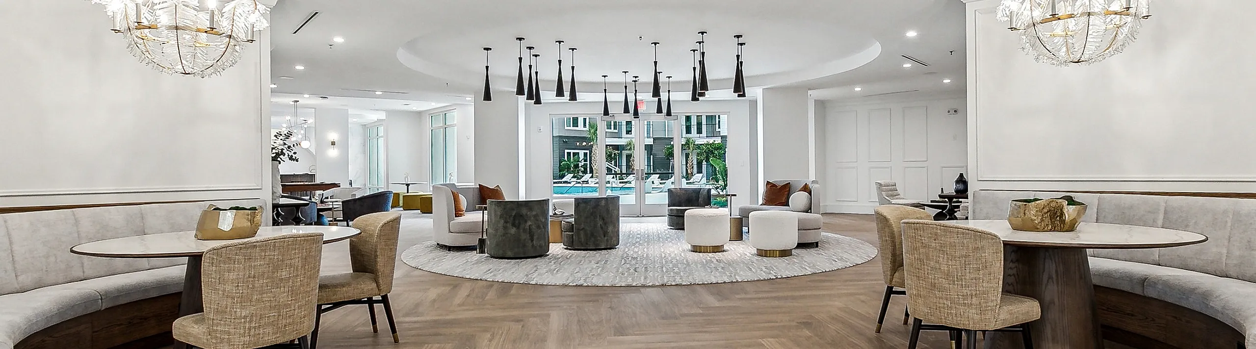 Elegant communal lounge with chic chandeliers, stylish seating, and an inviting open layout.