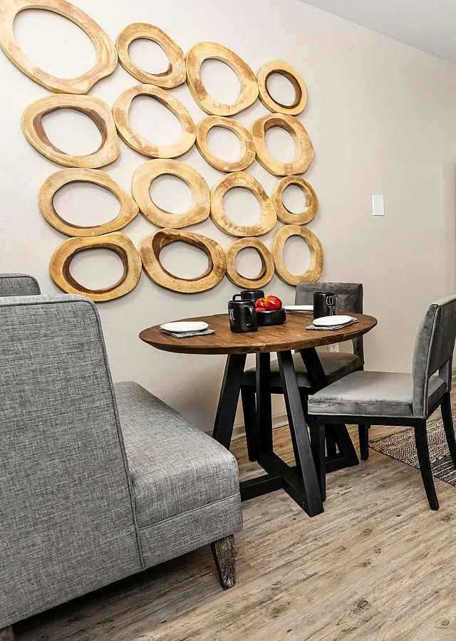 Chic modern kitchen with stainless steel appliances, a cozy dining area, and artistic wall decor, perfect for stylish living.