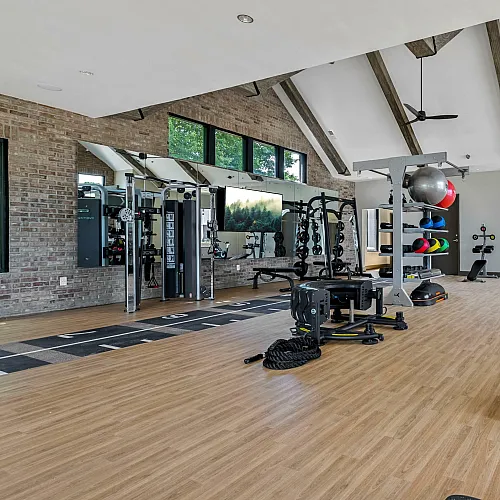 Spacious, modern fitness center with high ceilings, cardio machines, and a variety of strength training equipment.